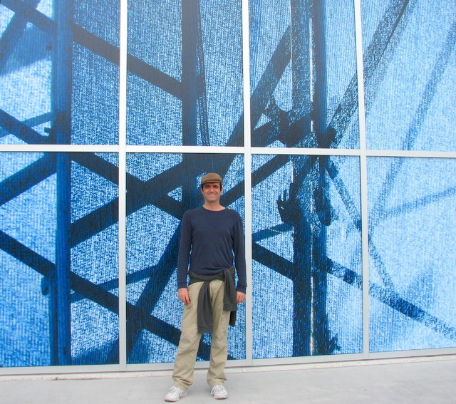 Paul Clemence standing in front of photo-wrap installation  Blue Sheer